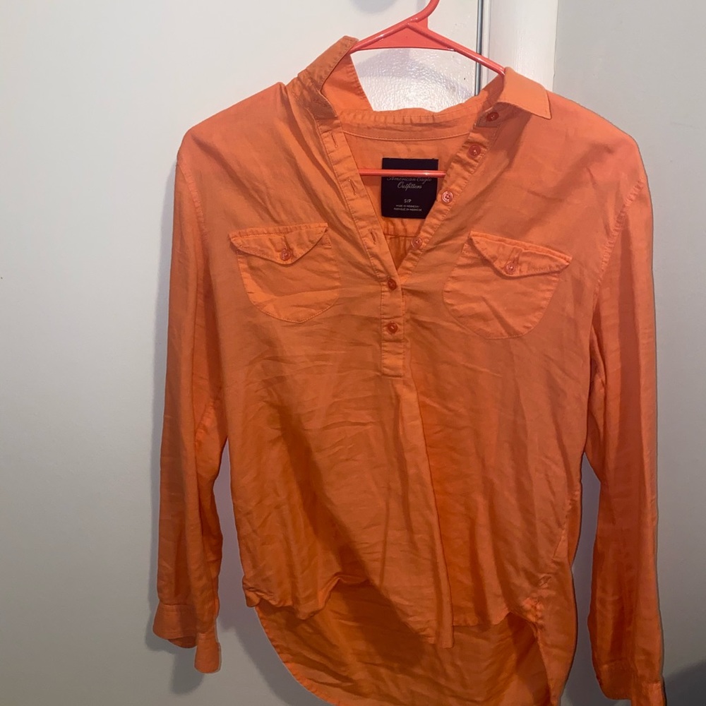 Peach colored, half button up blouse.